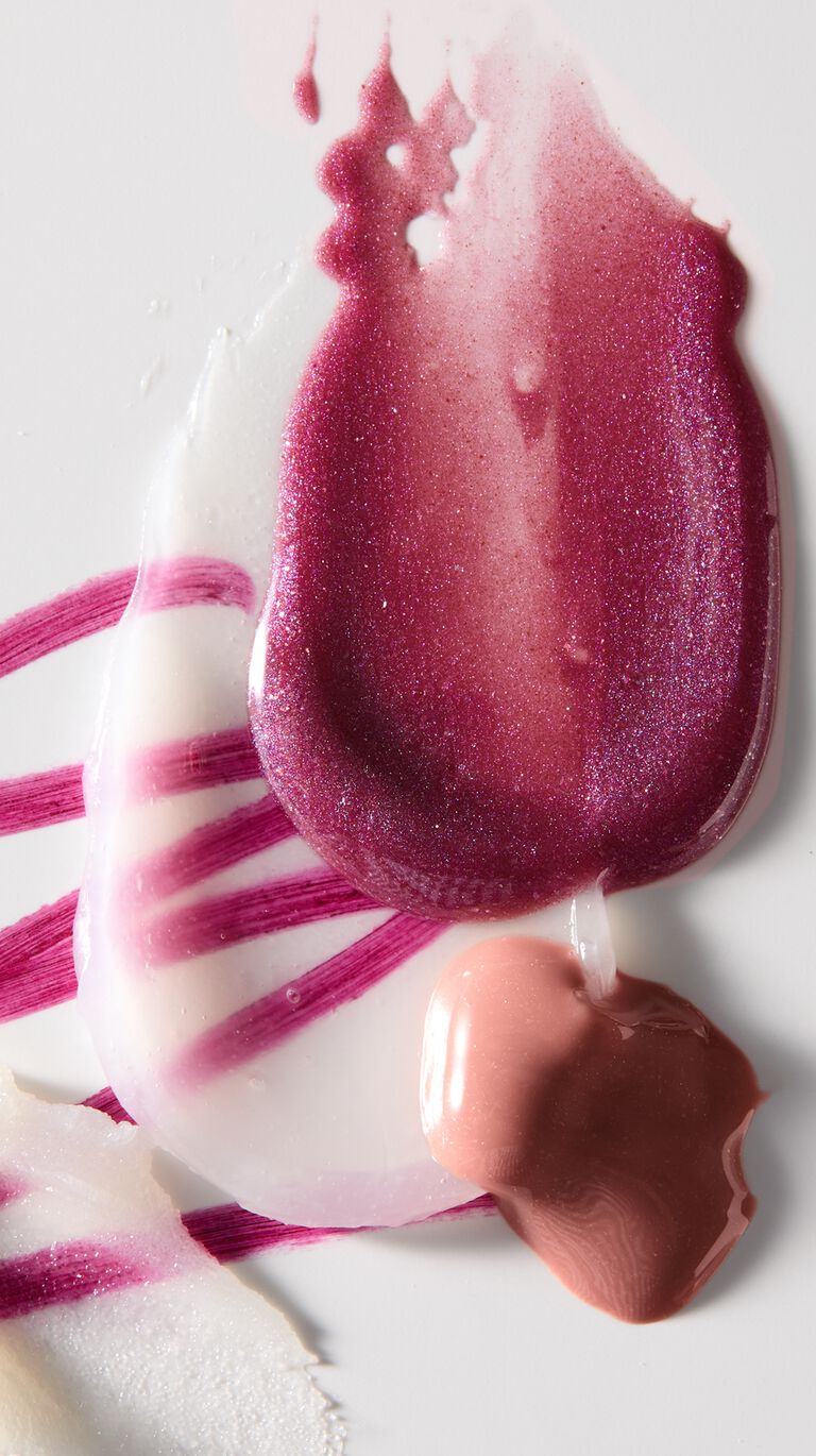 Layered product swatch featuring lip liner, lip balm, shea butter scrub, and lip gloss in nude and berry shades